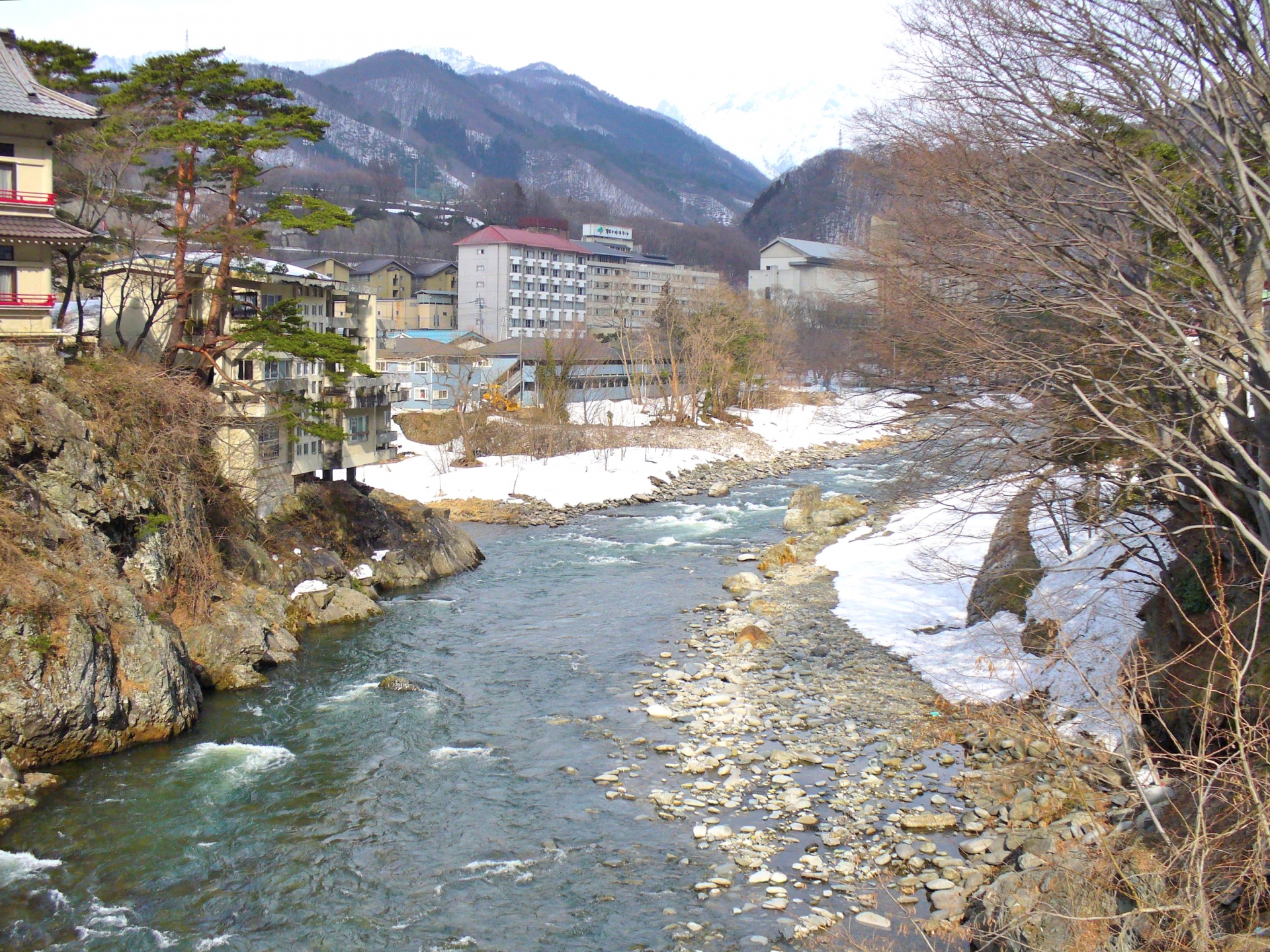 雪の残る山々と利根川沿いに広がる水上温泉街