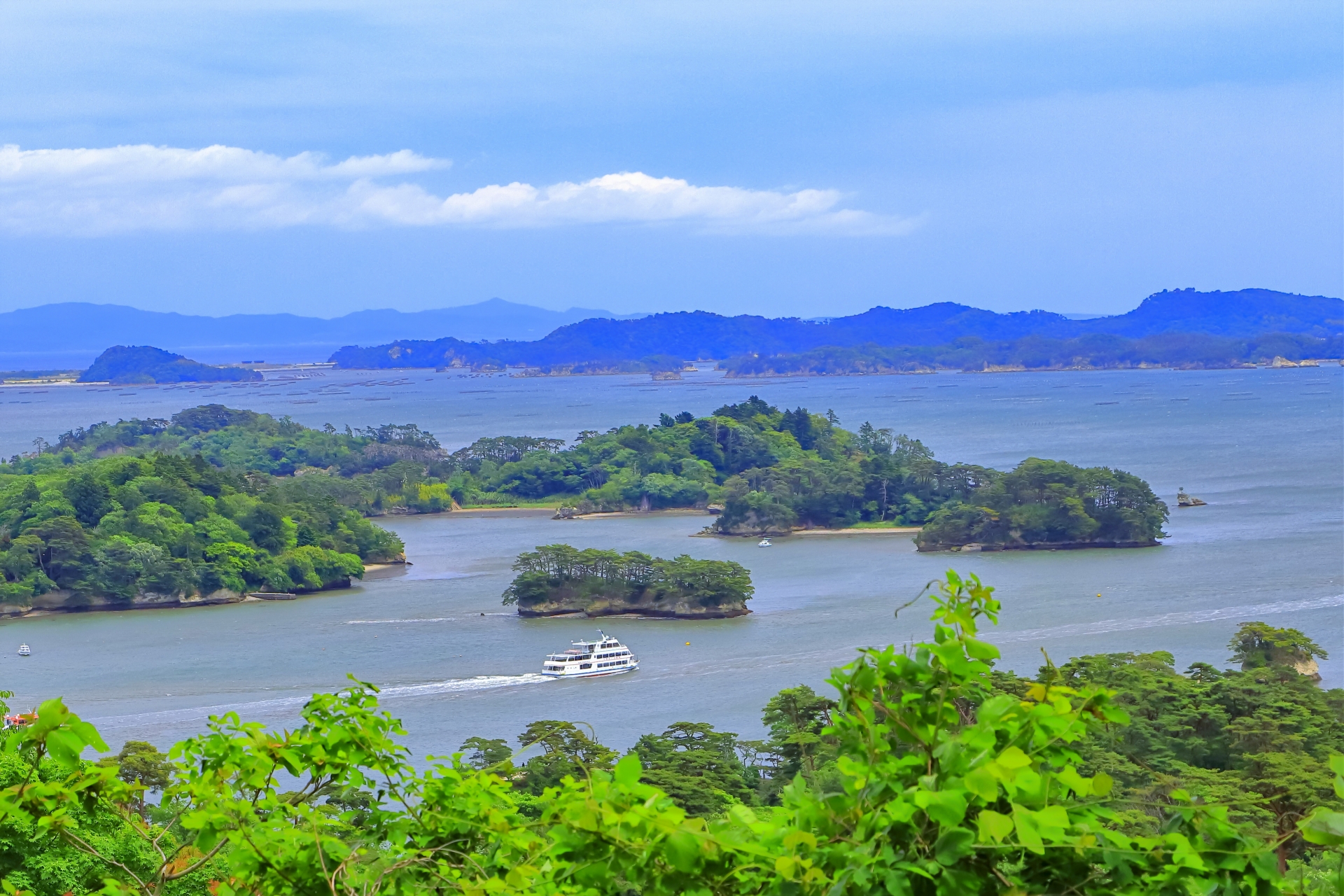 松島湾に浮かぶ島々と遊覧船の風景