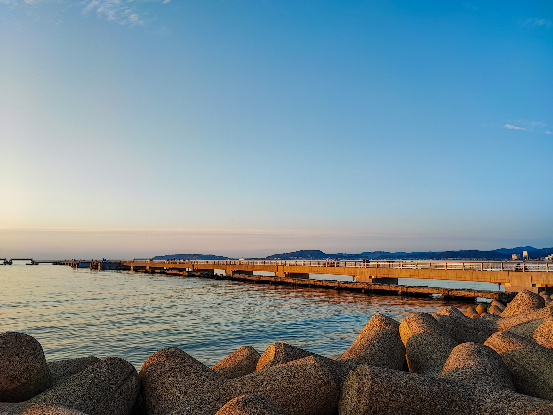 館山の穏やかな海と夕日に照らされた桟橋