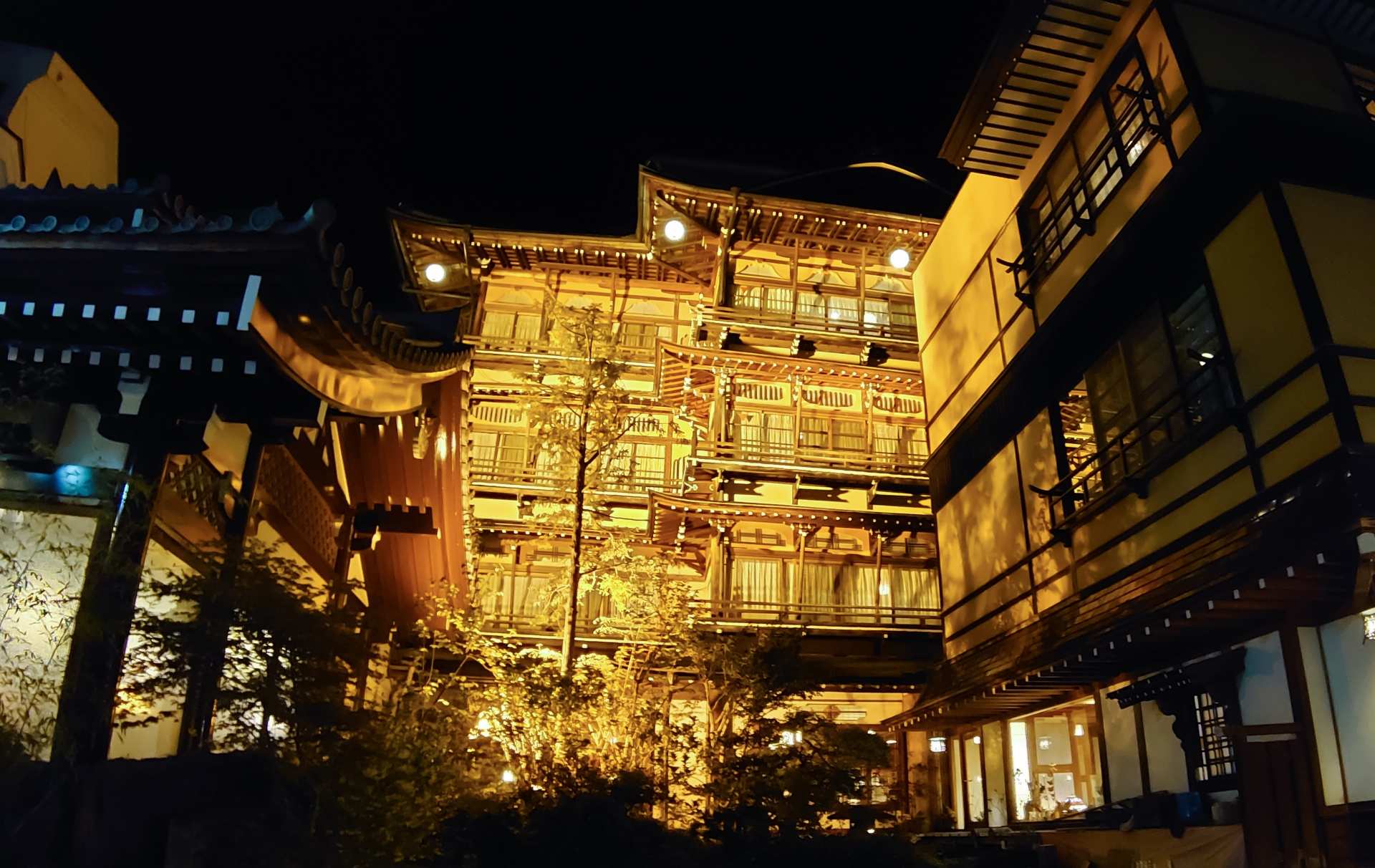夜の渋温泉街に浮かぶ歴史ある木造旅館の風景